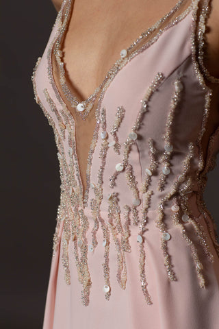 Blush pink evening gown with V-neckline, beaded bodice, open back and flowing A-line skirt.