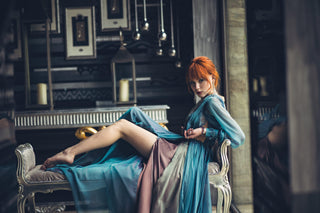 Blue chiffon gown with deep V neckline, long sheer sleeves, and high slit.