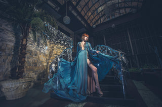 Blue chiffon gown with deep V neckline, long sheer sleeves, and high slit.