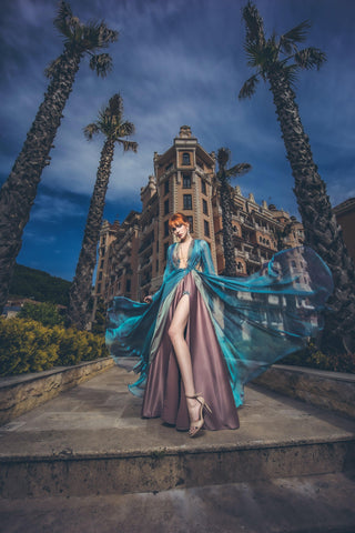 Blue chiffon gown with deep V neckline, long sheer sleeves, and high slit.