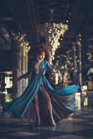 Blue chiffon gown with deep V neckline, long sheer sleeves, and high slit.