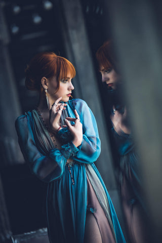 Blue chiffon gown with deep V neckline, long sheer sleeves, and high slit.